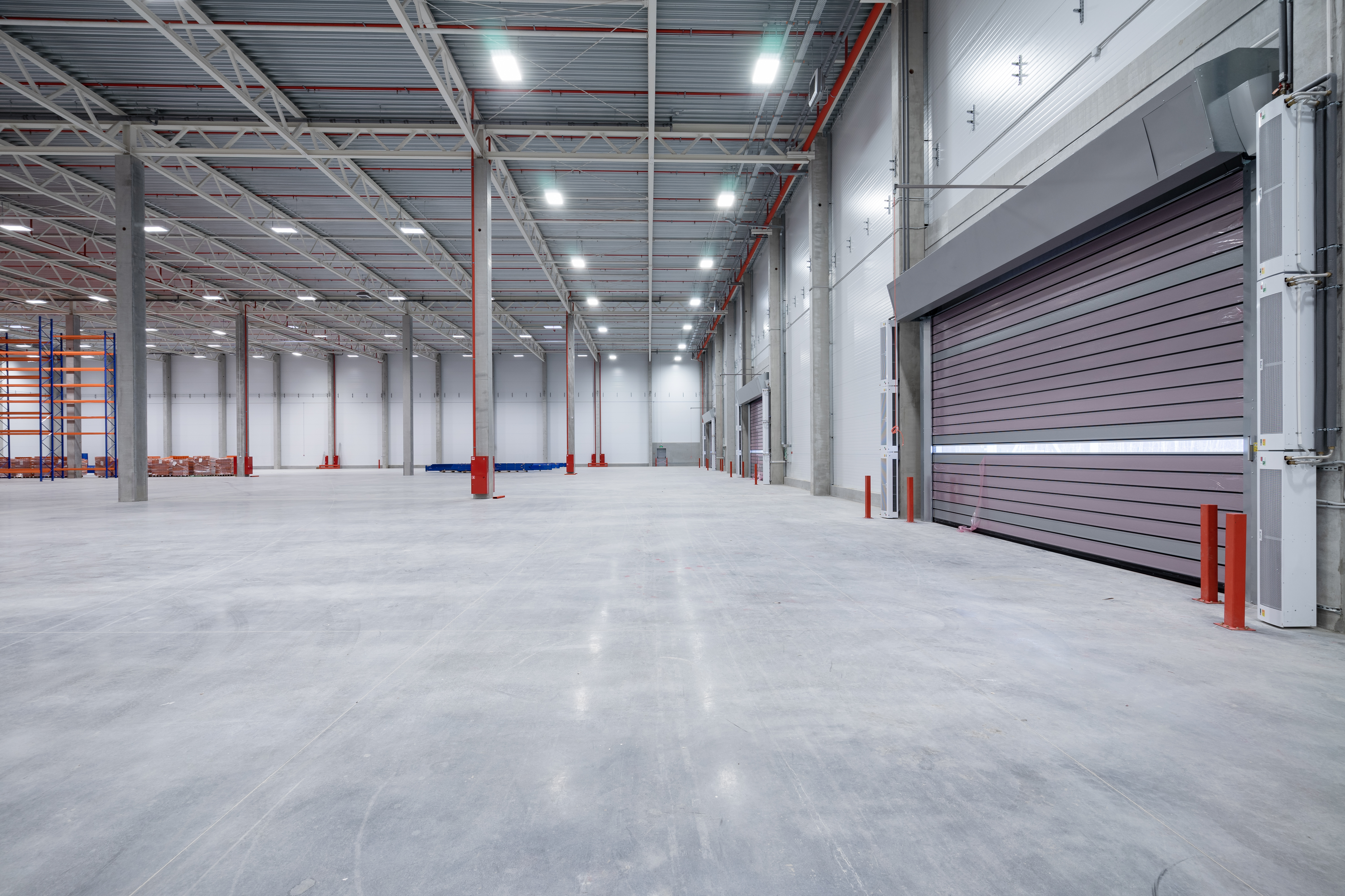 warehouse or hangar. Industrial building interior consist of polished concrete floor and closed door for product display or industry background.